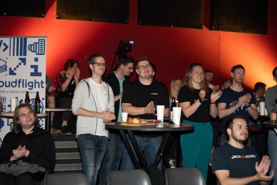 Personen stehen/sitzen im Publikum und applaudieren.