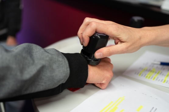 Nahaufnahme von zwei Händen mit einem Stempel